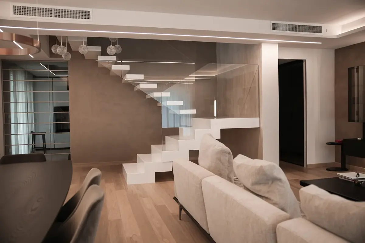 scala monoblocco in corian bianco, con ringhiera in cristallo