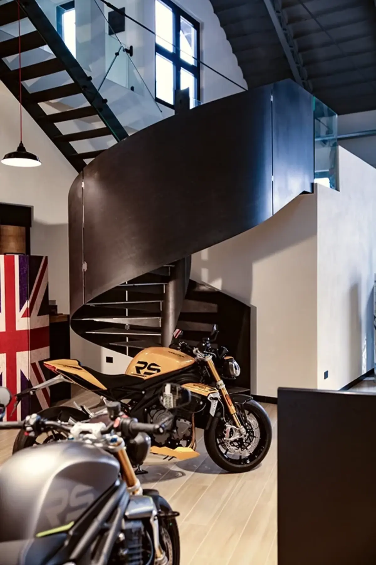scala in acciaio brunito nero, con struttura curva in stile industriale