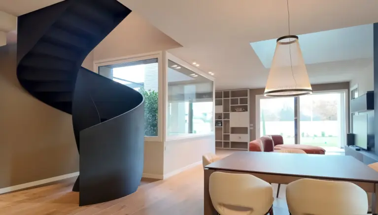 scala elicoidale in acciaio nero inserita nel soggiorno moderno