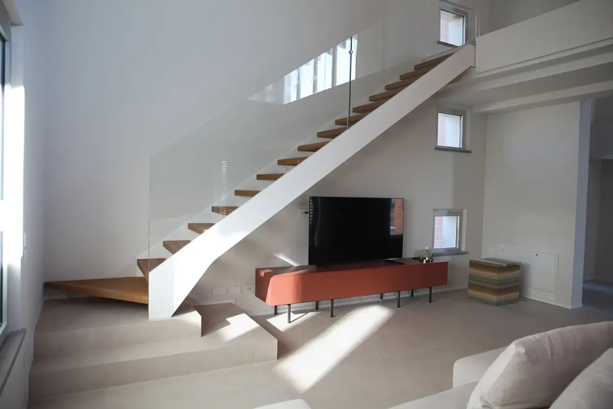 scala lineare con fascioni in acciaio bianco e ringhiera in vetro