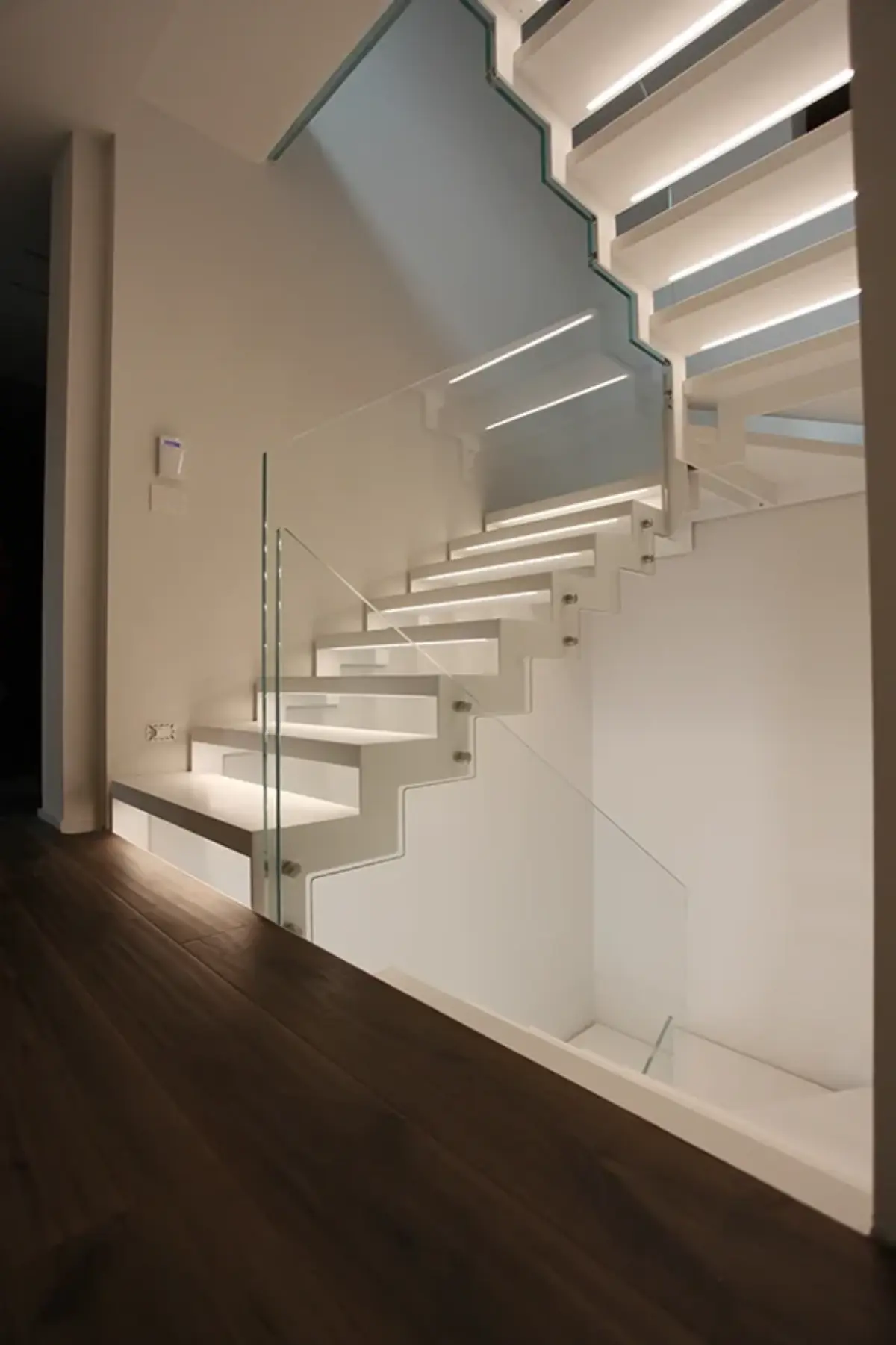 scala a rampa vista dal lato con ringhiera in vetro e fissaggio con bulloni